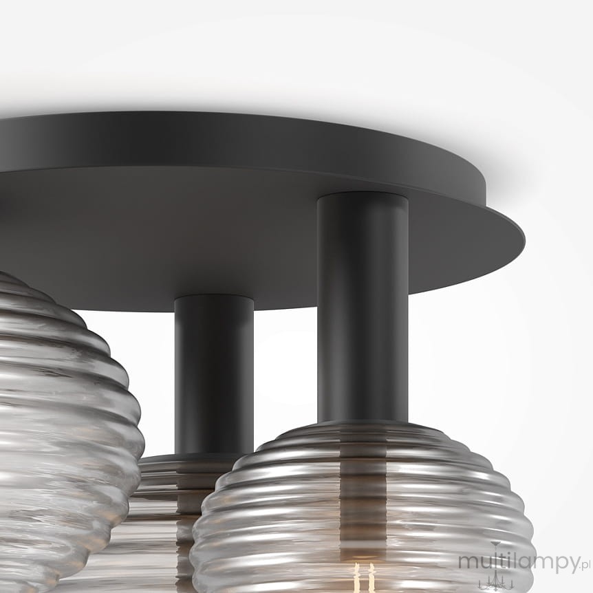 Lampa sufitowa Reels 3xE14 w kolorze czarnym, z okrągłą podstawą i trzema szklanymi kloszami o falistej fakturze. Klosze mają przezroczystą barwę, a całość montowana jest na prostych, czarnych rurkach.