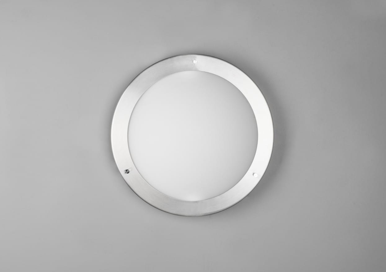 Plafon Condus IP44 w kolorze niklowym, z okrągłą, mleczną szybą. Ujęcie frontalne, produkt zamontowany na gładkiej, jasnej powierzchni. Widoczne mocowania w postaci dwóch śrub. Przeznaczony do użycia z żarówką E27.