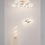 Złota lampa sufitowa LED Tessara o mocy 72W i temperaturze barwowej 3000K, z okrągłym kloszem i dekoracyjnymi elementami, zawieszona na ścianie. W tle widoczna jest lampa stojąca oraz kinkiet w podobnym stylu.
