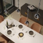 Lampa wisząca Ross 1xGU10 w kolorze czarnym z transparentnym kloszem, zawieszona nad białym stołem. W tle widoczne brązowe krzesła oraz dekoracyjny stół z talerzami, szklankami i butelką, w otoczeniu roślinności.