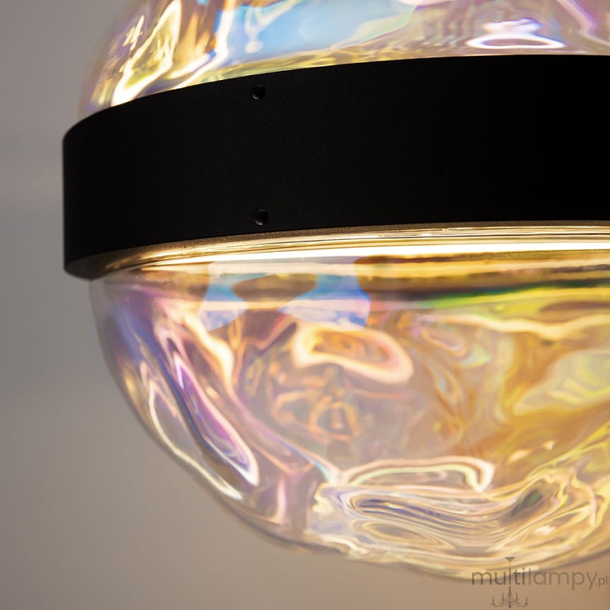 Lampa wisząca LED Misterio 6W, 2700K w czarnej oprawie. Szklany klosz o falowanej strukturze, odbijający różne kolory. Widok zbliżony, ukazujący detale mocowania i efekt świetlny.