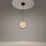Lampa wisząca LED Misterio o mocy 6W i temperaturze barwowej 2700K w kolorze czarnym. Okrągły klosz z efektownym, wielokolorowym wzorem, zawieszony na cienkim przewodzie, montowany do sufitu. Tło proste, szare.