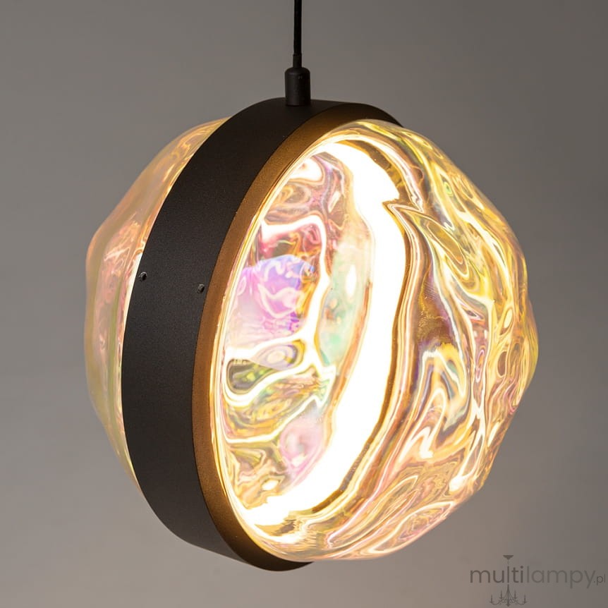 Lampa wisząca LED Misterio w kolorze czarnym, z okrągłym kloszem o przezroczystej, falistej strukturze, emitującym ciepłe światło (2700K). Klosz osadzony na metalowej podstawie z delikatnym złotym detalem. Zawieszona na czarnym przewodzie.