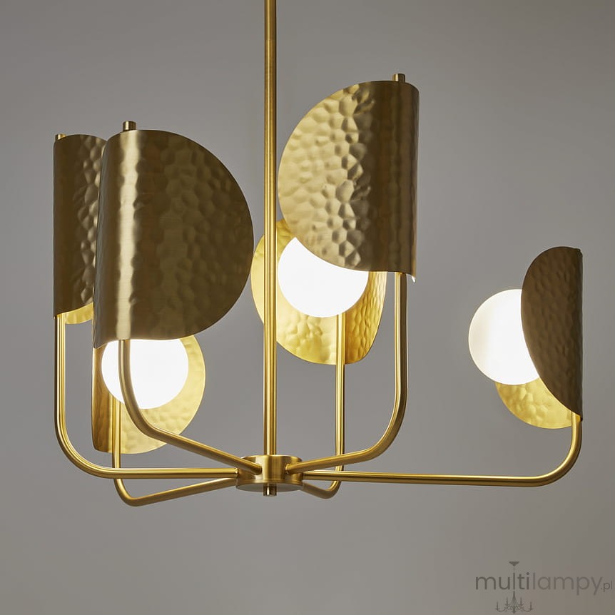 Lampa wisząca Tropic w kolorze mosiądzu z sześcioma oprawami G9. Posiada dekoracyjne, teksturowane klosze w kształcie półokręgów, które otaczają białe, okrągłe żarówki, umieszczone na metalowej konstrukcji.