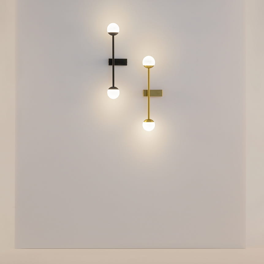 Kinkiet LED Touch w kolorze czarnym, moc 13W, temperatura barwowa 3000K. Ułożony na ścianie, z okrągłymi kloszami w górnej i dolnej części. Obok znajduje się kinkiet w kolorze złotym, tworzący nowoczesną aranżację.