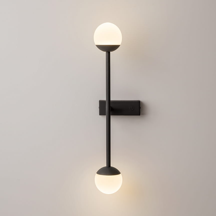 Kinkiet LED w kolorze czarnym, z dwoma szklanymi kulami emitującymi ciepłe światło (3000K). Montowany na ścianie, z prostą konstrukcją i eleganckim wykończeniem. Idealny do nowoczesnych wnętrz.