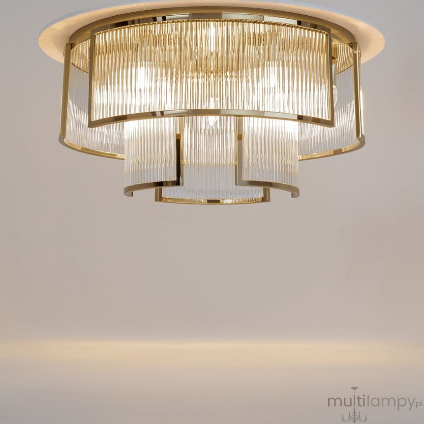 Lampa sufitowa Frame z 9 gniazdami E14 w kolorze złotym, z kloszami z przezroczystego szkła w delikatne prążki. Ujęcie z dołu, ukazujące elegancki design i subtelne detale, na jednolitym tle.