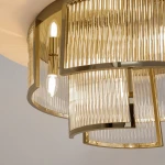 Lampa sufitowa Frame z sześcioma gniazdami E14, z metalowym, złotym wykończeniem. Szklane klosze z poziomymi żłobieniami tworzą elegancki efekt świetlny. Produkt widoczny z bliska, z detalami na kloszach i montażu.