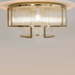 Lampa sufitowa Frame 6xE14 w kolorze złotym, z dekoracyjnymi, przezroczystymi kloszami o żłobionej fakturze. Ujęcie z góry, ukazujące elegancki design i źródła światła wewnątrz. Prosta, jasna aranżacja tła.