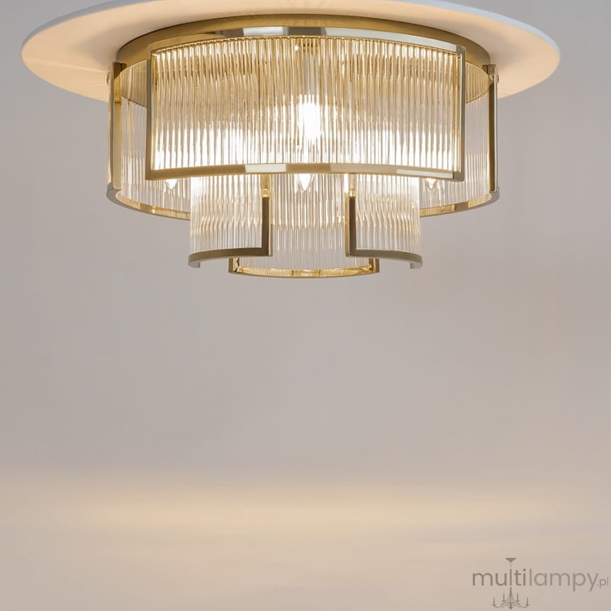 Lampa sufitowa Frame 6xE14 w kolorze złotym, z metalową konstrukcją i przezroczystym kloszem z pionowymi żłobieniami. Ujęcie z dołu, ukazujące detale lampy na jasnym tle. Elegancki design, idealna do nowoczesnych wnętrz.