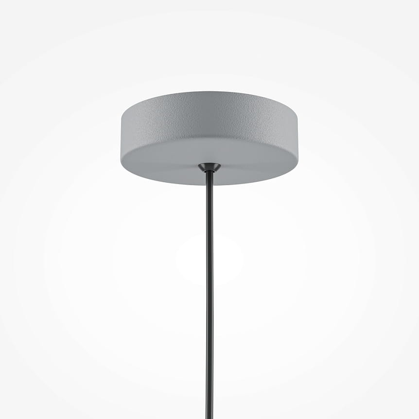 Lampa wisząca Basic Color 1xE27 w kolorze szarym. Posiada okrągły, matowy klosz z fakturą oraz długi, czarny przewód. Ujęcie frontalne, pokazujące lampę zawieszoną pod sufitem na jednolitym tle.