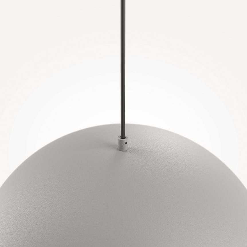 Szara lampa wisząca Basic Color z oprawą na żarówkę E27, o kulistym kształcie. Zawieszona na metalowym przewodzie, z widocznym mocowaniem u góry. Powierzchnia matowa, bez dodatkowych zdobień.