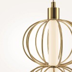 Lampa wisząca LED Golden Cage o mocy 17W i temperaturze barwowej 3000K. Złota konstrukcja z cienkich, okrągłych obręczy otaczających centralny, prosty element świetlny. Ujęcie z boku, na jasnym tle.