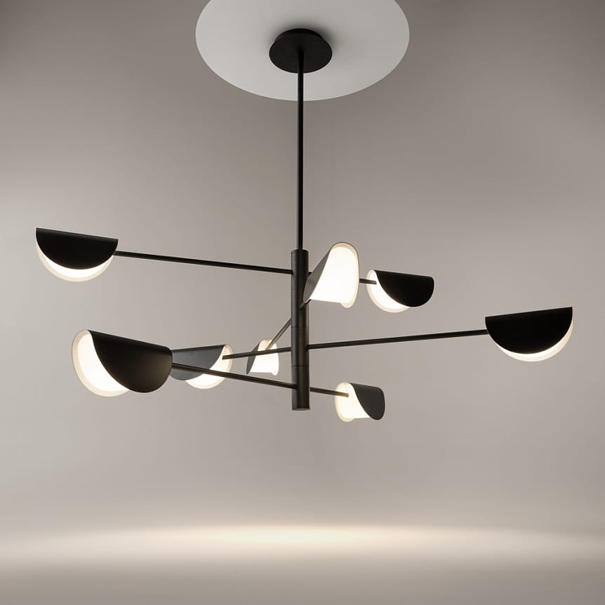 Lampa wisząca Mollis 8-punktowa w kolorze czarnym, z metalową konstrukcją i półokrągłymi kloszami w białym kolorze. Produkt zawieszony na cienkim, czarnym przewodzie, z okrągłym mocowaniem sufitowym.