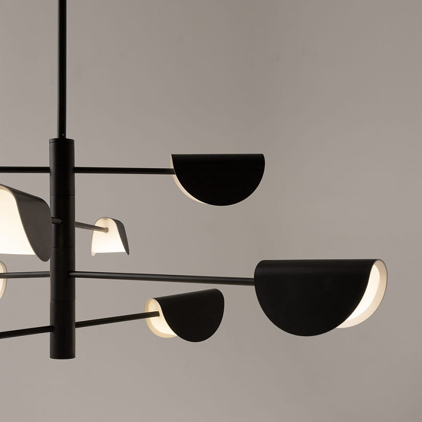 Lampa wisząca Mollis 8-punktowa w kolorze czarnym, z prostymi, półokrągłymi kloszami w białym kolorze. Ujęcie z boku, ukazujące elegancki, nowoczesny design i układ ramion. Produkt zawieszony w minimalistycznym otoczeniu na jasnym tle.