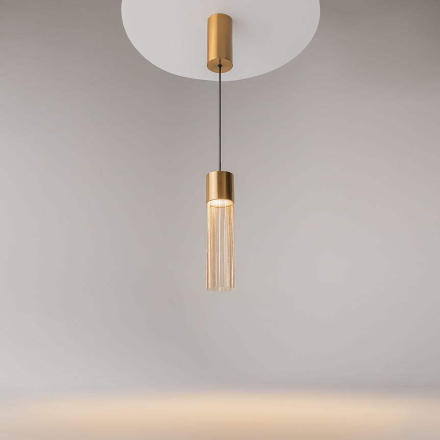 Lampa wisząca LED Imaginary o mocy 5W, kolor złoty. Produkt zawieszony na czarnym przewodzie, z cylindrycznym kloszem i dekoracyjnymi elementami. Światło o ciepłej barwie 3000K, w minimalistycznym, nowoczesnym stylu.