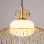 Lampa wisząca Levitation 1xG9 z mosiądzu, z okrągłym kloszem z białego szkła, otoczonym złotą, metalową siatką. Ujęcie z boku, pokazujące detal konstrukcji oraz zawieszenie. Tło jasne, neutralne.