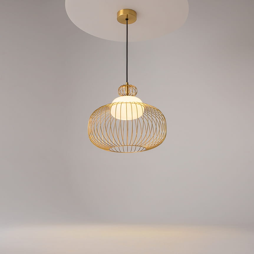 Lampa wisząca Levitation MOD376PL-01G w kolorze mosiądzu z przezroczystą osłoną. Okrągła, siatkowa konstrukcja z górnym uchwytem, zawieszona na czarnym przewodzie. Źródło światła G9. Tło jasne, minimalistyczne.