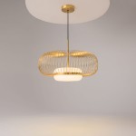 Lampa wisząca Levitation 1xG9 w kolorze mosiądzu z metalowym kloszem w formie ażurowej siatki. Ułożona na długim przewodzie, z białym, okrągłym elementem u podstawy, na tle szarej ściany.