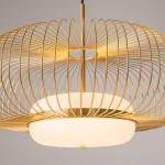 Lampa wisząca Levitation 1xG9 w kolorze mosiężnym. Okrągła, metalowa konstrukcja z delikatnymi, spiralnymi prętami. U podstawy znajduje się mlecznobiały klosz. Ujęcie z bliska, podkreślające detale oraz nowoczesny design.