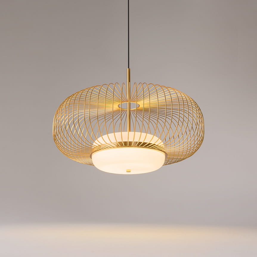 Lampa wisząca Levitation 1xG9 w kolorze mosiądzu, z okrągłą, matową oprawą i ażurową, złotą konstrukcją. Zawieszona na czarnym przewodzie, z widocznym źródłem światła w centralnej części. Tło w neutralnym odcieniu.