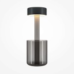 Lampa stołowa LED AI Collaboration o mocy 3W, w kolorze szarym z czarnym elementem. Posiada cylindryczny, transparentny klosz oraz prostą, minimalistyczną budowę. Ujęcie frontalne, produkt stoi na jednolitym tle.