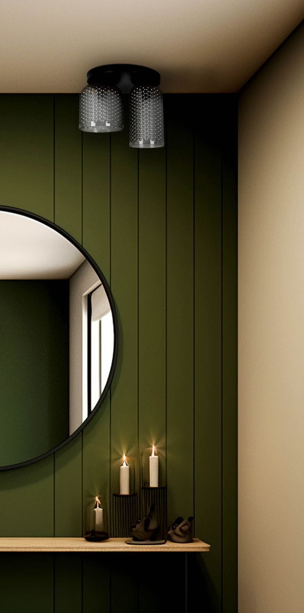 Lampa sufitowa Inga z dwoma oprawami E27 w kolorze czarnym i grafitowym. Zawieszona pod sufitem, posiada przezroczyste klosze z drobnymi wzorami, umieszczona w aranżacji z zieloną ścianą, lustrem oraz świecami na półce.