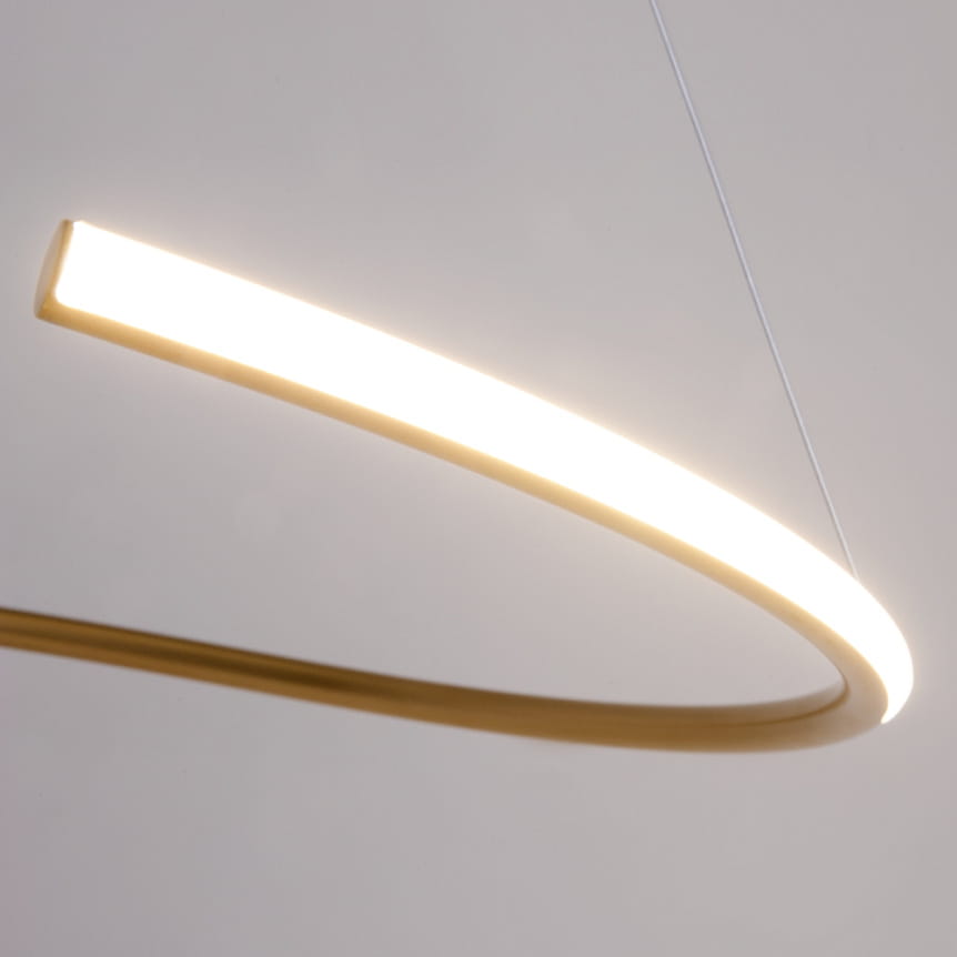 Lampa wisząca LED Curve o mocy 31W, z mosiężnym wykończeniem. Zawieszona w formie delikatnego łuku, emitująca ciepłe światło. Widoczny subtelny, zakrzywiony kształt, z białym źródłem światła na górze, zawieszona na cienkich linkach.