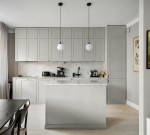 Lampa wisząca Aspen 1xG9 w kolorze czarnym z białym kloszem, zawieszona na długim kabelku, idealna do nowoczesnej kuchni. Produkt wisi nad wyspą kuchenną w jasnym, minimalistycznym wnętrzu z szarymi meblami i marmurowym blatem.