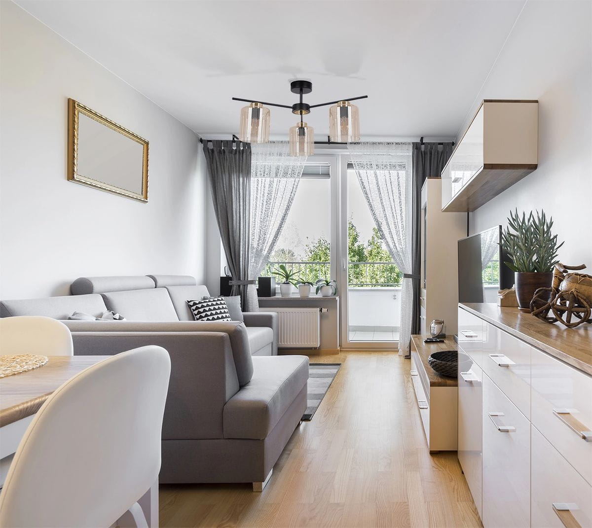 Lampa sufitowa Aurelia 3xE27 w kolorze czarnym z bursztynowymi kloszami, zamontowana na suficie w nowoczesnym wnętrzu. Stojący mebel obok, szare zasłony i rośliny w tle tworzą harmonijną aranżację.