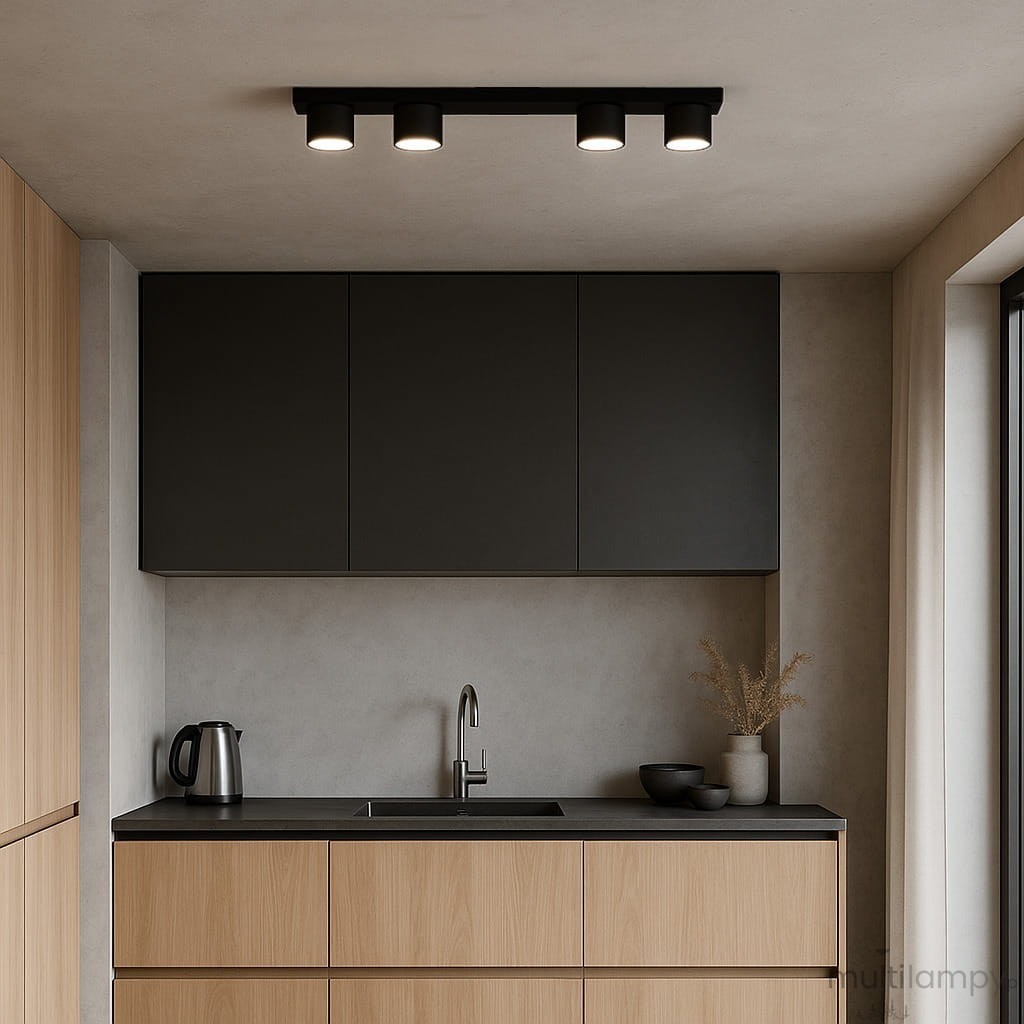 Cruz lampa sufitowa 4xGX53 w kolorze czarnym, montowana na suficie. Cztery okrągłe klosze o minimalistycznym designie, umieszczone na prostokątnej podstawie. Lampa znajduje się nad ciemnym blatem kuchennym w nowoczesnym wnętrzu.