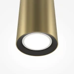 Lampa wisząca Pro Focus w kolorze złotym, z oprawą w kształcie cylindrycznym, z miejscem na żarówkę GU10. Widoczna czarna obwódka wokół źródła światła. Ujęcie z dołu, w zbliżeniu na detal klosza.