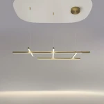 Lampa wisząca LED Radiance w złotym kolorze, o mocy 80W i temperaturze barwowej 3000K. Posiada nowoczesny, minimalistyczny design z dwoma poziomymi ramionami, zawieszona na cienkich linkach. Montaż sufitowy, na jasnym tle.