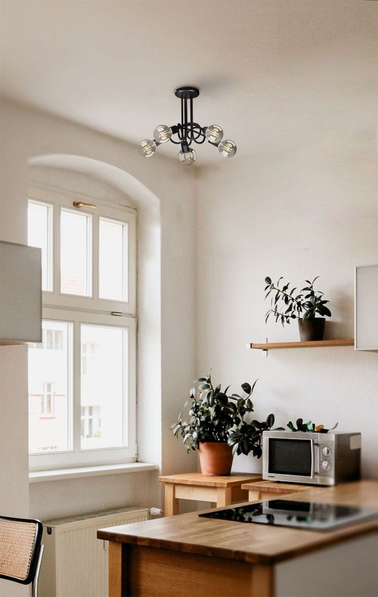 Czarna lampa sufitowa K-3621 z pięcioma oprawami E27, zamontowana na suficie w kuchni. Widoczny minimalistyczny design, metalowa konstrukcja z okrągłym mocowaniem, w otoczeniu drewnianych mebli i roślin doniczkowych.