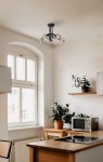 Czarna lampa sufitowa K-3621 z pięcioma oprawami E27, zamontowana na suficie w kuchni. Widoczny minimalistyczny design, metalowa konstrukcja z okrągłym mocowaniem, w otoczeniu drewnianych mebli i roślin doniczkowych.