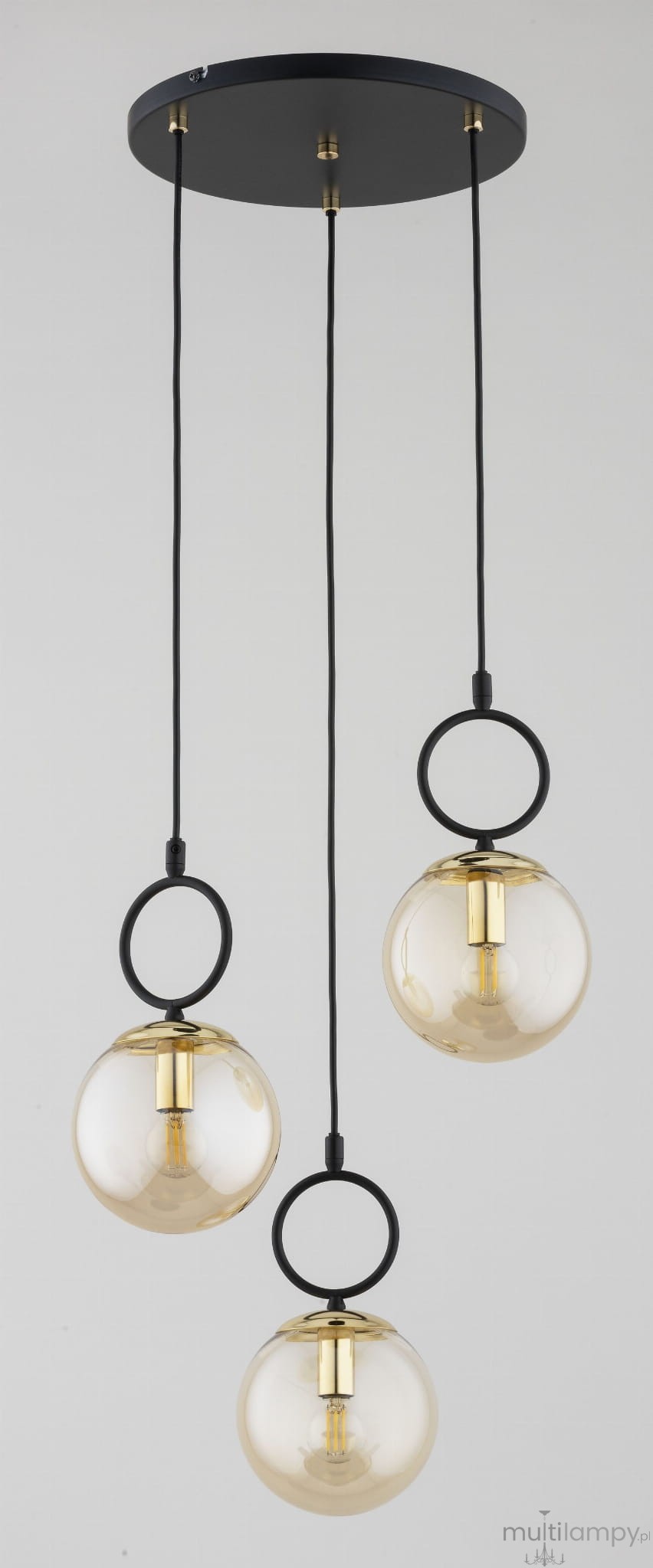 Lampa wisząca Lister 3xE14 w kolorze czarno-złotym. Składa się z trzech szklanych kul z przezroczystym kloszem zawieszonych na czarnych kablach. Metalowe elementy w kolorze złotym, okrągłe pierścienie u podstawy kul.