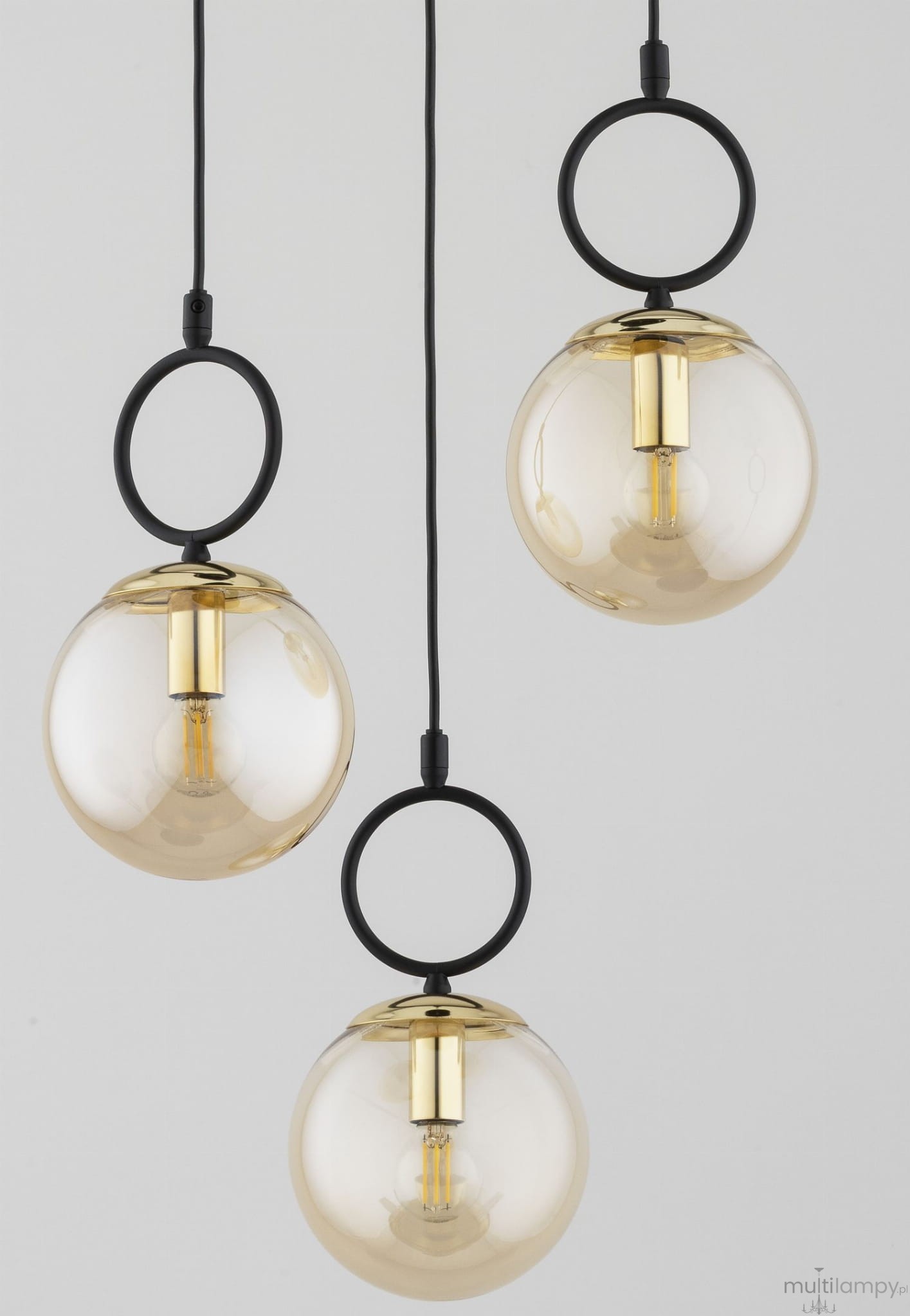 Lampa wisząca Lister 3xE14 w czarno-złotej kolorystyce, składająca się z trzech okrągłych kloszy z przezroczystego szkła, zawieszonych na czarnych linkach. Każdy klosz ma złote detale i jest w kształcie kuli. Tło jasne, minimalistyczne.