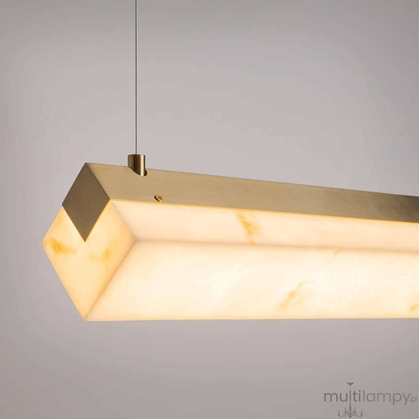 Lampa wisząca LED Petra w kolorze mosiądzu, o prostokątnym kształcie, z przezroczystym kloszem z delikatnym wzorem. Zawieszona na cienkim przewodzie, idealna do nowoczesnych wnętrz. Wymiary: 35W, 3000K.