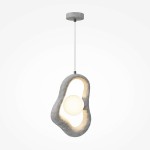 Lampa wisząca Opus w kolorze szarym z jedną oprawą G9. Posiada organiczny, nieregularny kształt z okrągłym, białym kloszem w centralnej części. Zawieszona na cienkim przewodzie, z metalowym mocowaniem sufitowym. Tło jednolite.