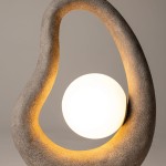 Lampa stołowa Opus z szarym, teksturowanym stelażem w kształcie organicznej formy, z białą, okrągłą żarówką G9 umieszczoną w środku. Produkt o nowoczesnym designie, stojący na płaskiej powierzchni. Tło neutralne.
