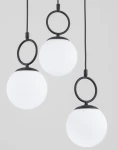 Lampa wisząca Sitro z trzema białymi, okrągłymi kloszami na czarnych mocowaniach. Klosze zawieszone są na cienkich przewodach, tworząc nowoczesny design. Całość na jasnym tle, podkreślającym elegancki styl lampy.