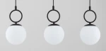 Lampa wisząca Sitro z trzema okrągłymi kloszami z matowego białego szkła, zawieszona na czarnych metalowych pierścieniach. Produkt widoczny z przodu, na jednolitym tle. Idealna do nowoczesnych wnętrz.