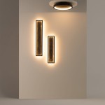 Czarna lampa sufitowa LED Orign 27W 3000K, zamontowana na jasnej ścianie, emitująca ciepłe światło. W tle dwa prostokątne panele o strukturze drewna, podświetlone od dołu. Lampa ma okrągły, minimalistyczny kształt.