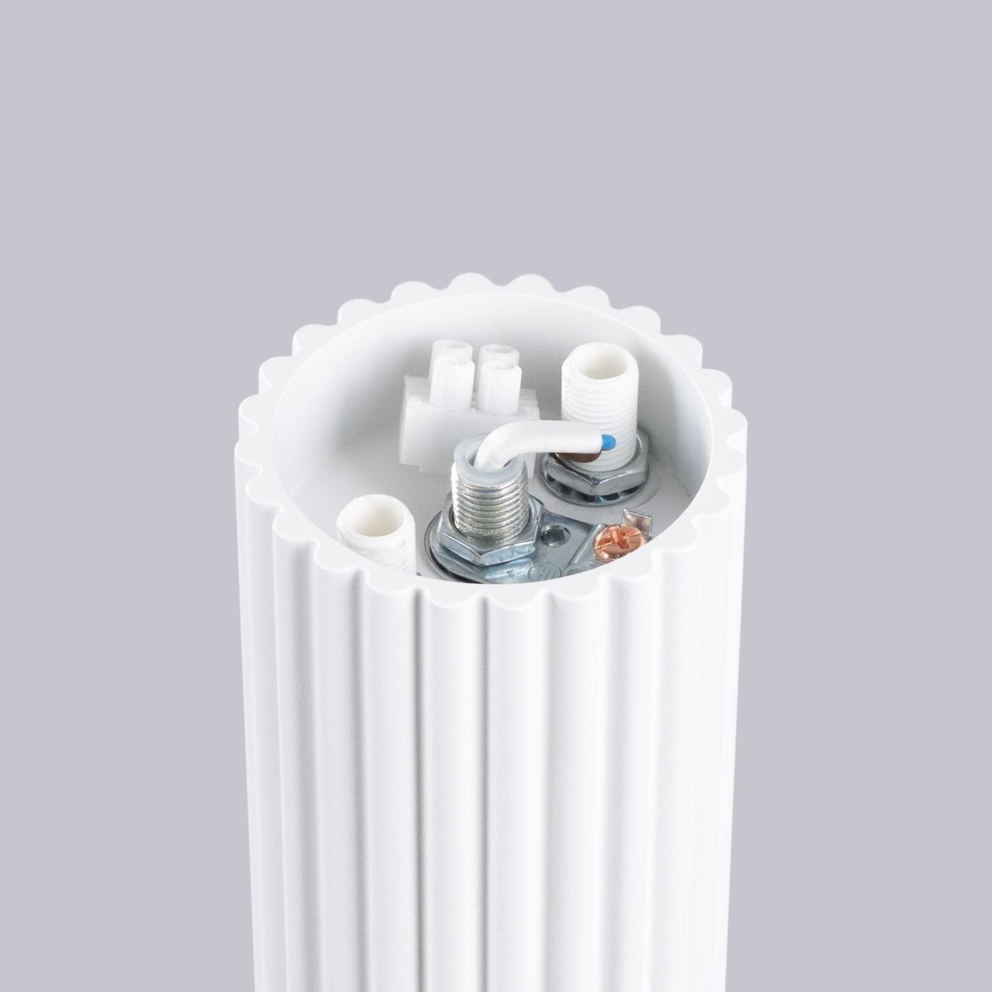 Lampa sufitowa Halo 1xG9 IP44 o białym kolorze i żebrowanej fakturze. Widok z góry na wnętrze lampy, z widocznymi elementami montażowymi, przewodami oraz gniazdem na żarówkę. Tło w odcieniu szarym.