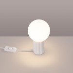 Lampa stołowa Halo z białą, okrągłą żarówką G9 na cylindrycznej podstawie z rowkami. Produkt z włącznikiem na kablu, umieszczony na jasnym tle. Idealna do nowoczesnych wnętrz.