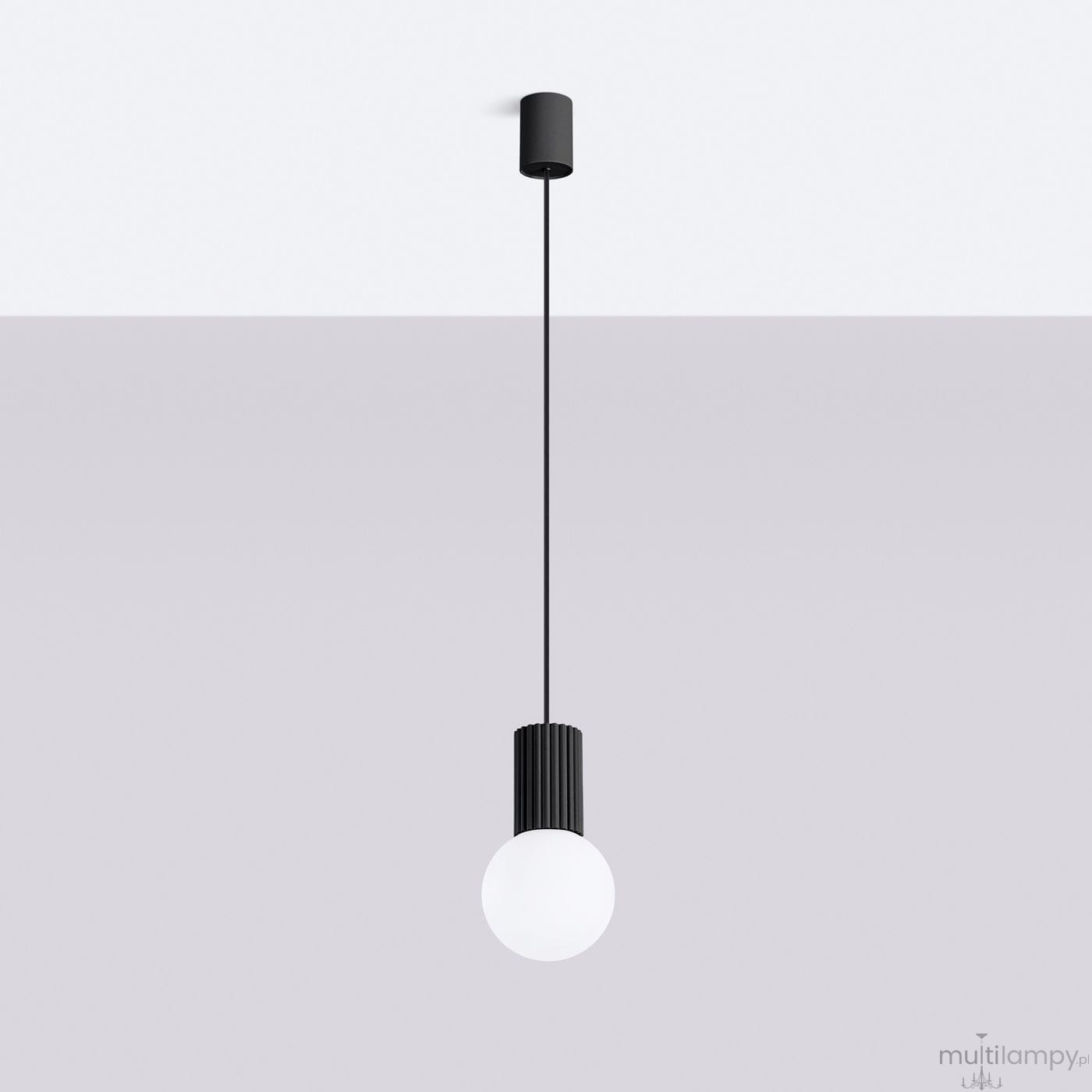 Czarna lampa wisząca Halo z oprawą na jedną żarówkę G9. Posiada prosty, cylindryczny kształt z teksturowanym elementem u góry oraz okrągłą, białą kulę na dole. Powieszona na cienkim przewodzie, wisi w minimalistycznym otoczeniu na jasnym tle.
