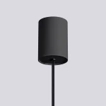 Czarna lampa wisząca Halo o cylindrycznym kształcie, wykonana z matowego materiału. Ujęcie z dołu, pokazujące detal mocowania oraz przewód. Idealna do nowoczesnych wnętrz.