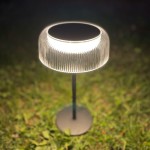 Lampa stołowa solarna LED Bluet o mocy 2,5W, barwie światła 3000K, z czarną podstawą i kloszem z teksturowanego szkła, stojąca na trawie. Klosz emituje miękkie światło, podkreślając kształt i fakturę. IP44, odporna na warunki atmosferyczne.