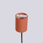 Lampa wisząca Halo 1xG9 w kolorze ochry czerwonej. Cylindryczny klosz z matowego materiału z widocznym gniazdem na żarówkę. Kabel w czarnym oplocie. Ujęcie z góry, na jednolitym tle.
