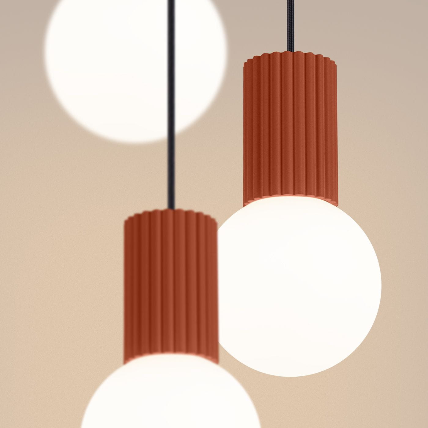 Lampa wisząca Halo 3xG9 w kolorze ochra czerwona z trzema okrągłymi kloszami. Klosze wykonane z mlecznego szkła, zamocowane na falistych, czerwonych podstawach. Lampa zawieszona na czarnych przewodach, na jednolitym tle.